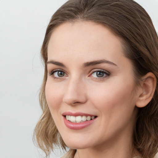 Joyful white young-adult female with long  brown hair and grey eyes