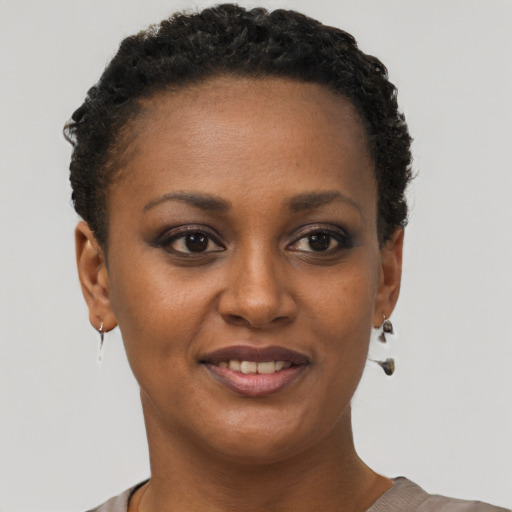 Joyful black young-adult female with short  brown hair and brown eyes