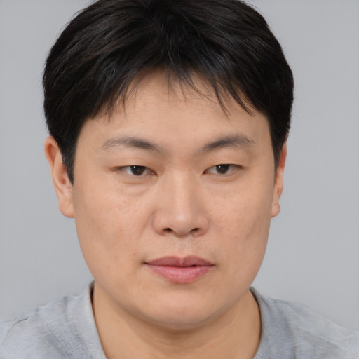 Joyful asian young-adult male with short  brown hair and brown eyes