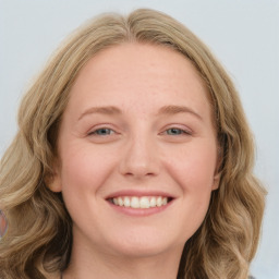 Joyful white young-adult female with long  brown hair and blue eyes