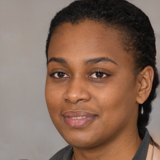 Joyful black young-adult female with medium  black hair and brown eyes