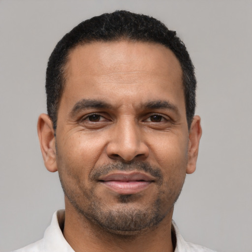 Joyful latino adult male with short  black hair and brown eyes