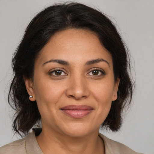 Joyful latino adult female with medium  brown hair and brown eyes