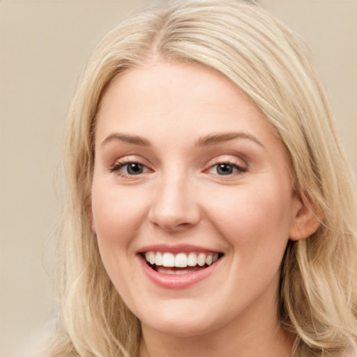 Joyful white young-adult female with long  brown hair and blue eyes