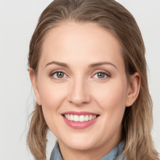 Joyful white young-adult female with long  brown hair and blue eyes