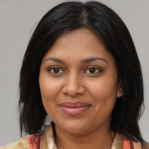 Joyful black young-adult female with medium  brown hair and brown eyes