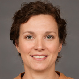 Joyful white adult female with medium  brown hair and grey eyes