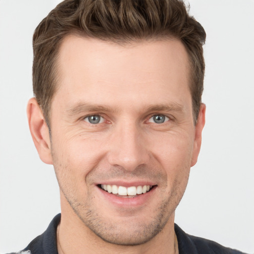 Joyful white young-adult male with short  brown hair and grey eyes