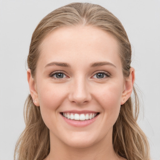 Joyful white young-adult female with long  brown hair and grey eyes