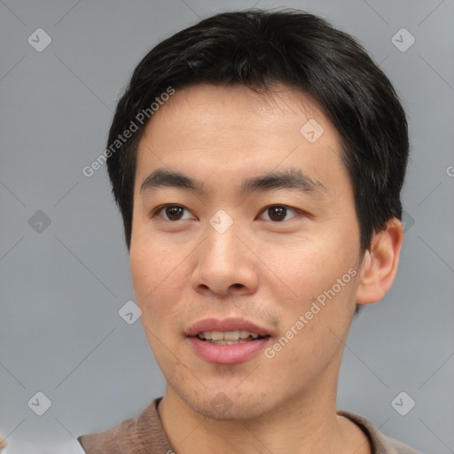 Joyful asian young-adult male with short  brown hair and brown eyes