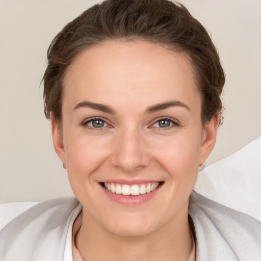 Joyful white young-adult female with short  brown hair and brown eyes