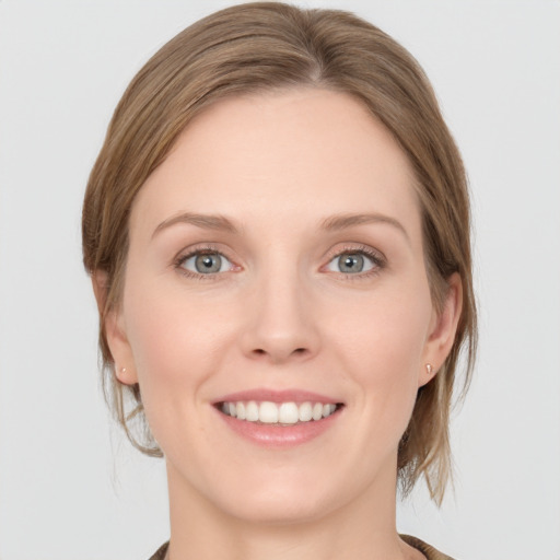 Joyful white young-adult female with medium  brown hair and grey eyes