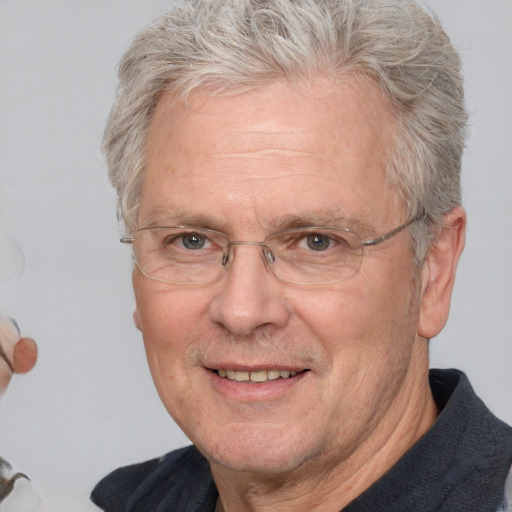 Joyful white middle-aged male with short  gray hair and blue eyes