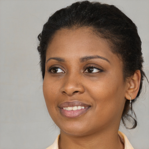 Joyful black young-adult female with medium  brown hair and brown eyes