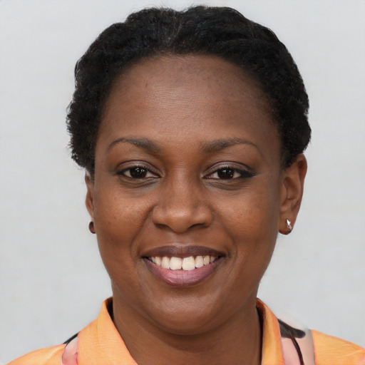 Joyful black adult female with short  brown hair and brown eyes