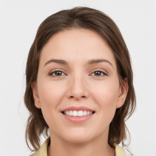 Joyful white young-adult female with medium  brown hair and grey eyes