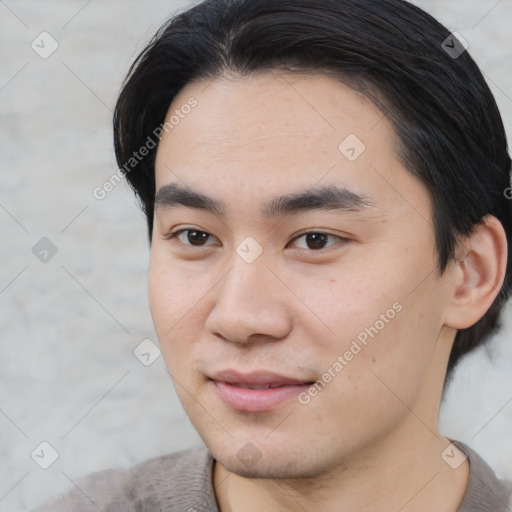 Joyful asian young-adult male with short  brown hair and brown eyes