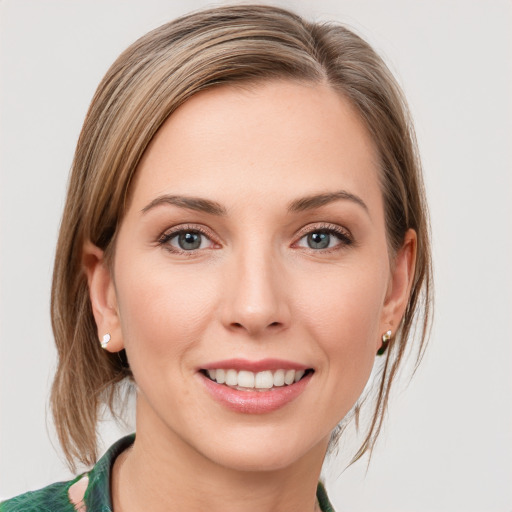 Joyful white young-adult female with medium  brown hair and green eyes