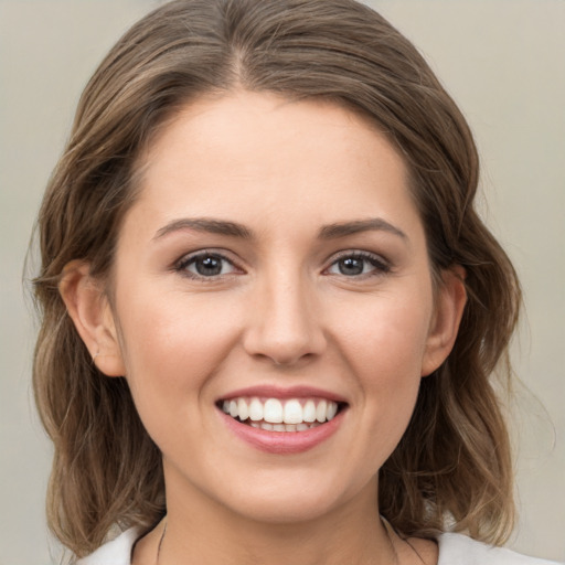 Joyful white young-adult female with medium  brown hair and green eyes