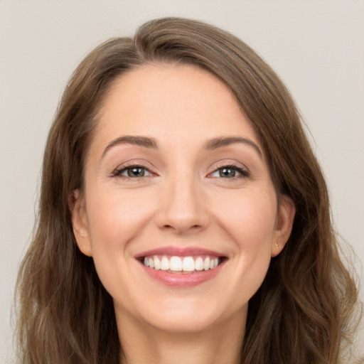 Joyful white young-adult female with long  brown hair and green eyes