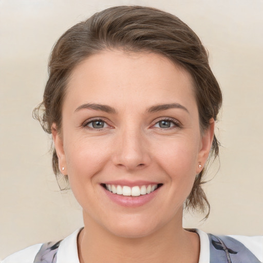 Joyful white young-adult female with medium  brown hair and grey eyes