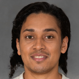 Joyful latino young-adult male with short  brown hair and brown eyes