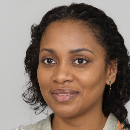 Joyful black young-adult female with medium  black hair and brown eyes