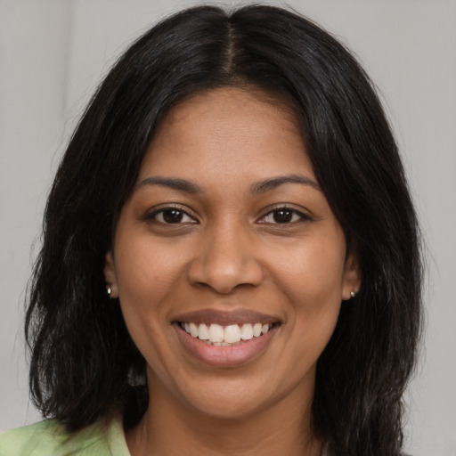 Joyful black young-adult female with long  black hair and brown eyes