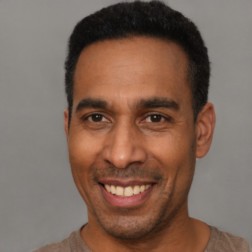 Joyful latino adult male with short  black hair and brown eyes