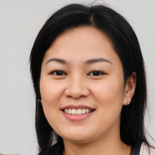 Joyful asian young-adult female with long  black hair and brown eyes