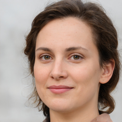 Joyful white young-adult female with medium  brown hair and green eyes