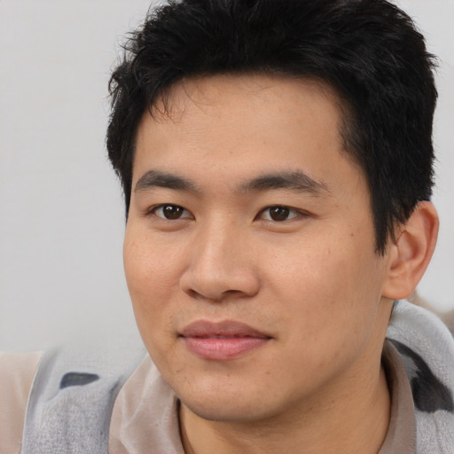 Joyful asian young-adult male with short  black hair and brown eyes
