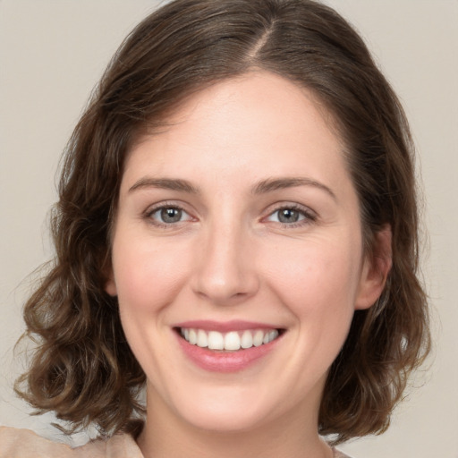 Joyful white young-adult female with medium  brown hair and green eyes