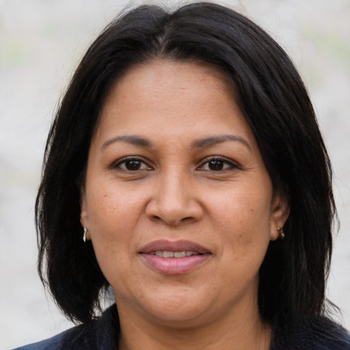 Joyful latino adult female with medium  brown hair and brown eyes