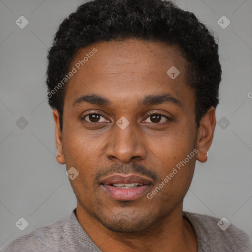 Joyful black young-adult male with short  black hair and brown eyes