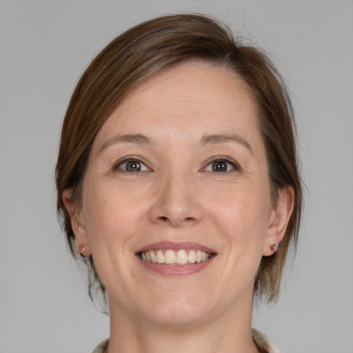 Joyful white adult female with medium  brown hair and grey eyes