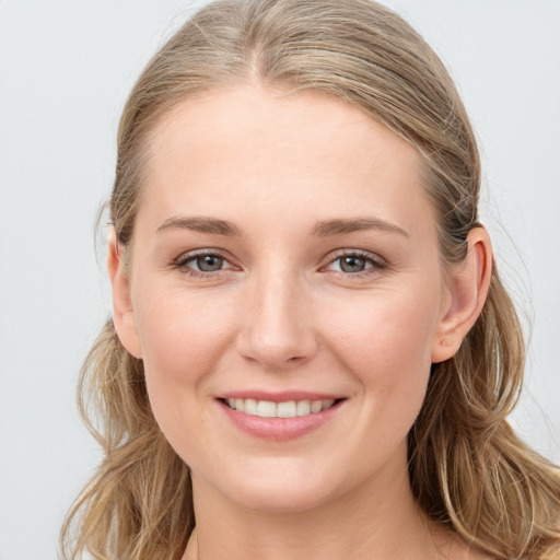 Joyful white young-adult female with long  brown hair and blue eyes