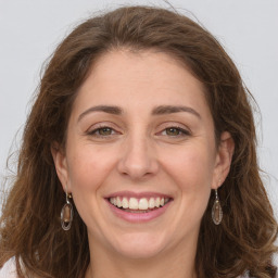 Joyful white young-adult female with long  brown hair and green eyes