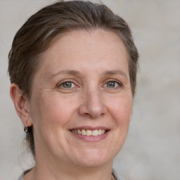 Joyful white adult female with short  brown hair and grey eyes