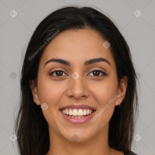 Joyful latino young-adult female with long  brown hair and brown eyes