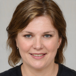 Joyful white young-adult female with medium  brown hair and blue eyes