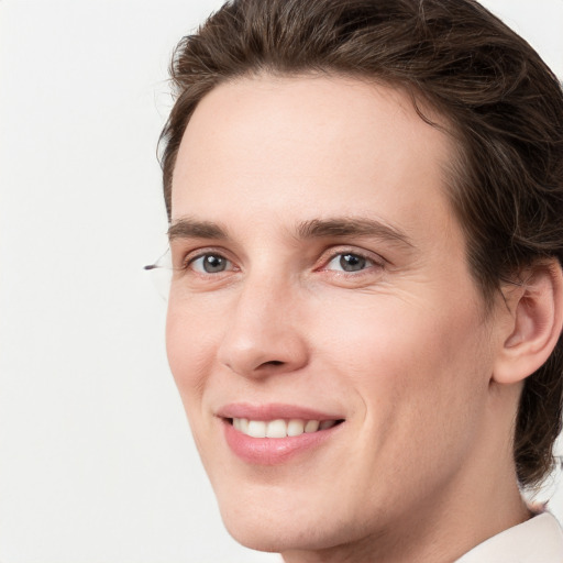 Joyful white young-adult male with medium  brown hair and grey eyes