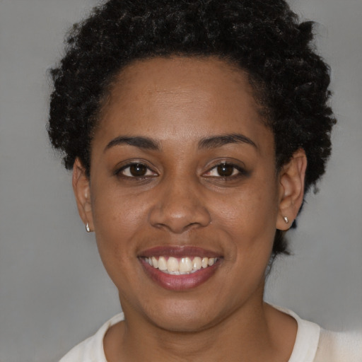 Joyful black young-adult female with short  brown hair and brown eyes