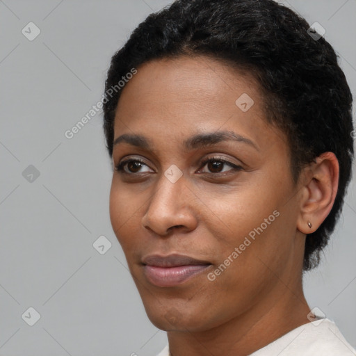 Joyful black young-adult female with short  black hair and brown eyes