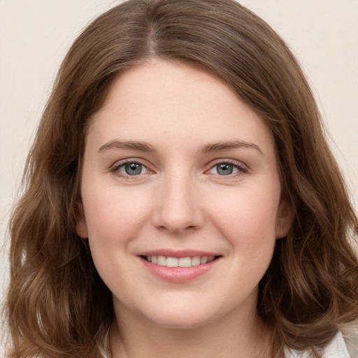 Joyful white young-adult female with long  brown hair and green eyes