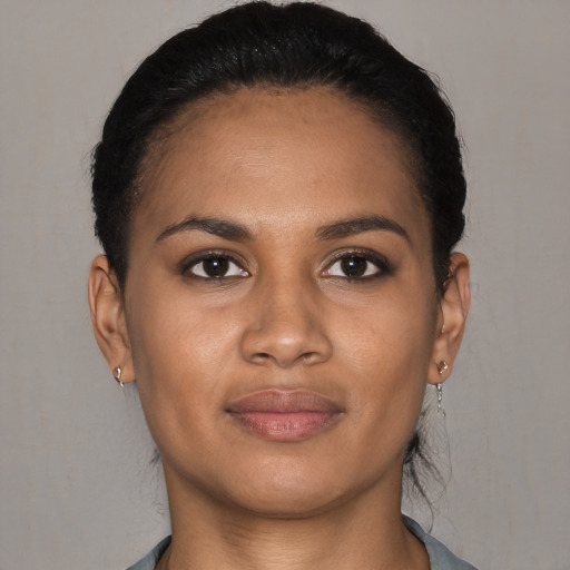 Joyful black young-adult female with short  black hair and brown eyes
