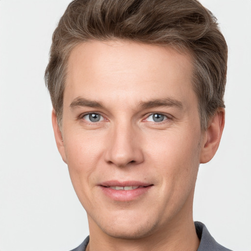 Joyful white young-adult male with short  brown hair and grey eyes