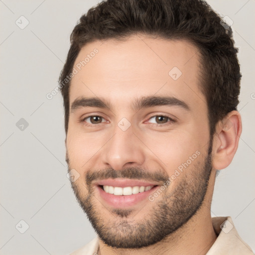 Joyful white young-adult male with short  brown hair and brown eyes