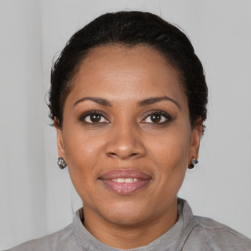 Joyful black young-adult female with short  black hair and brown eyes