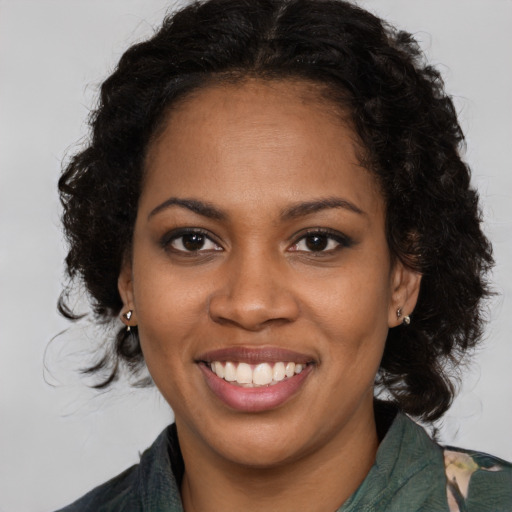 Joyful black young-adult female with long  brown hair and brown eyes